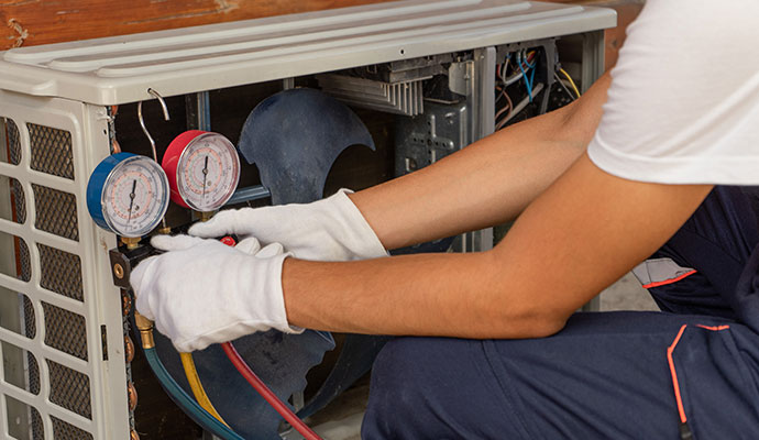 HVAC technician checking refrigerant levels with manifold gauges