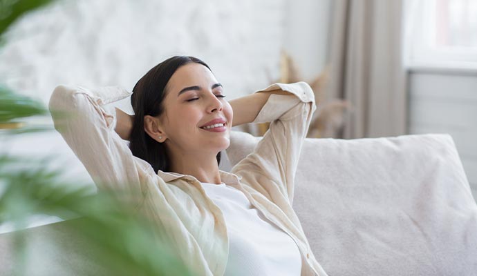 A woman relaxing comfortably on a white sofa