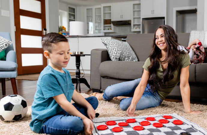 A baby boy playing indoors with his mom