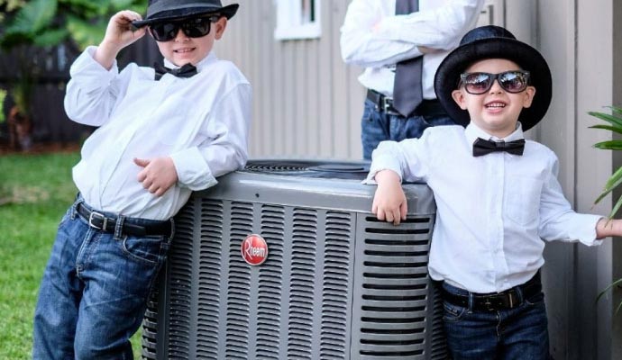 Kids posing around air conditioning unit