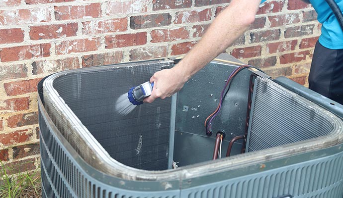 worker cleaning heat pump