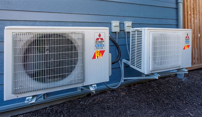 Two wall-mounted Mitsubishi Electric outdoor heat pump units