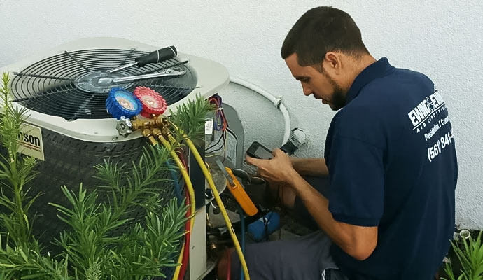 Technician using diagnostic tools on outdoor air conditioning unit