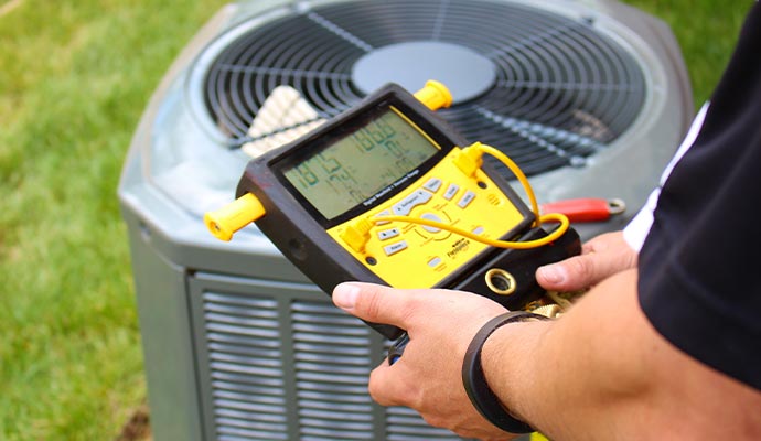 Expert inspecting heating system with a digital device Technician using a digital device to inspect a heating system