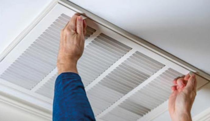 A person changing HVAC filter