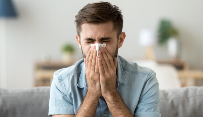 Person suffering from allergies due to poor indoor air quality