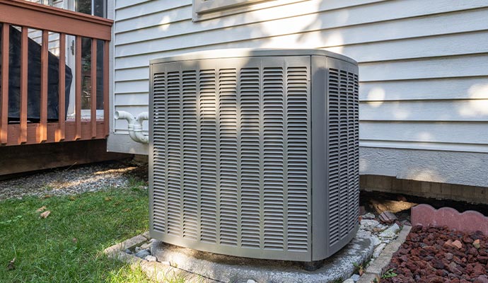 Air conditioner condenser unit installed near a residential house