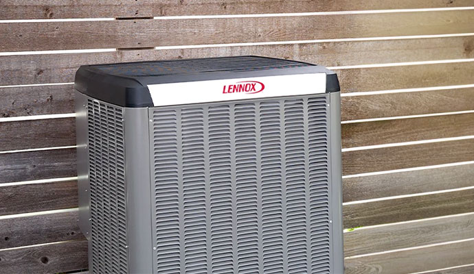 A Lennox outdoor air conditioning unit installed next to a horizontal wood fence