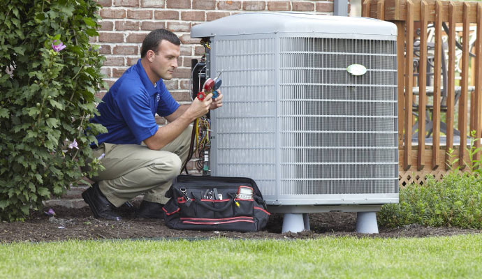 A professional inspecting an AC using equipment