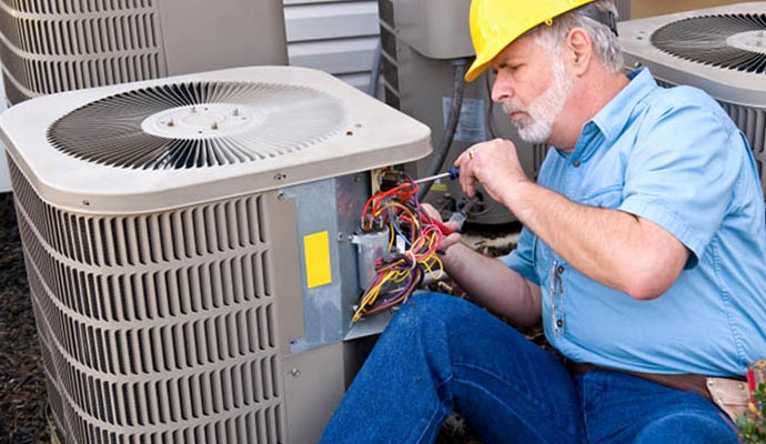 worker repairing heat pump
