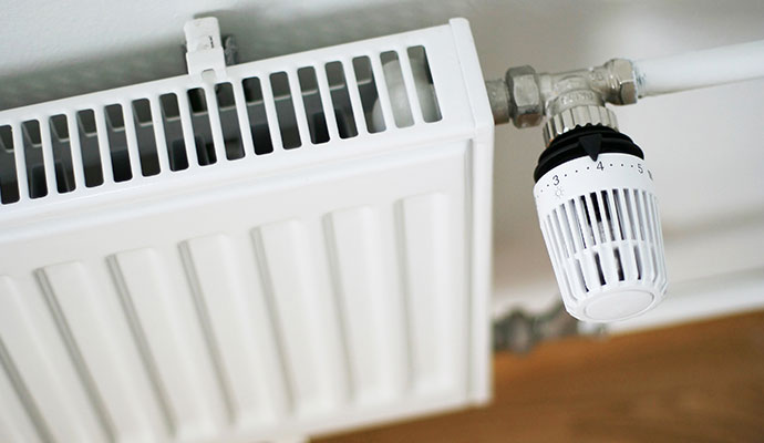 White heating radiator panel equipped with a thermostatic control valve