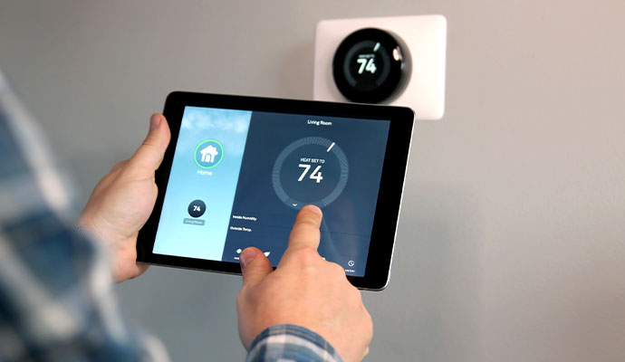 Person adjusting smart thermostat temperature controls on a digital tablet