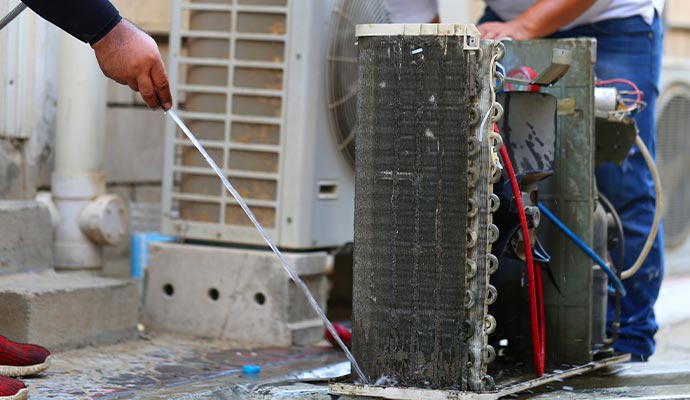 worker is cleaning heat pump