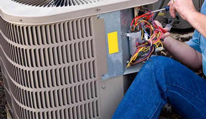 worker repairing heat pump